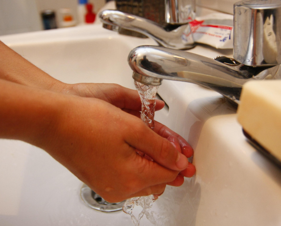 Una persona se lava las manos en el grifo