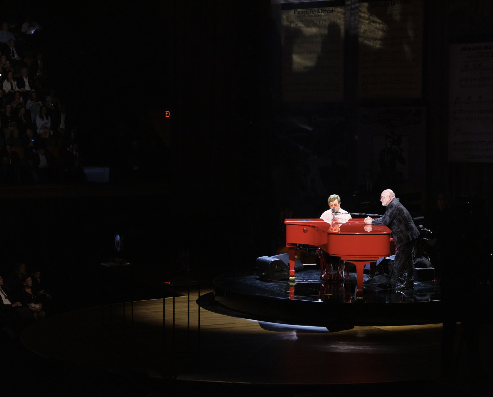 Elton John (i) mientras interpreta Your Song con su compañero compositor Bernie Taupin