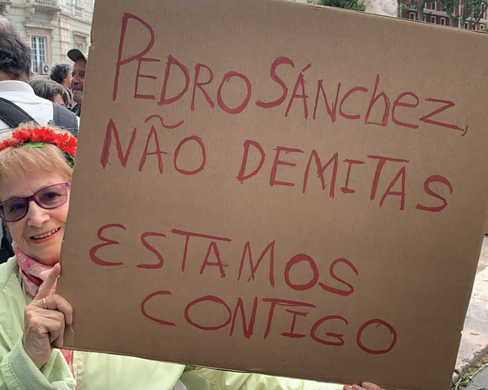 LISBOA, 25/04/2024.- Asistentes al desfile por el 50 aniversario de la Revolución de los Claveles que ha recorrido hoy jueves las calles de Lisboa, muestran carteles en apoyo al presidente del Gobier