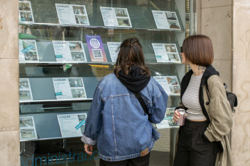 GRAFCAT1202. BARCELONA, 12/03/2024.- Dos personas observan la oferta de pisos en alquiler de una oficina inmobiliaria de Barcelona este martes, a pocos días de que se publique, el próximo viernes, l