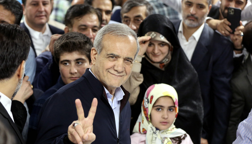Tehran (Iran(islamic Republic Of)), 28/06/2024.- Iranian reformist presidential candidate Masoud Pezeshkian (C) flashes a victory sign as he arrives to cast his vote at a polling station during the pr