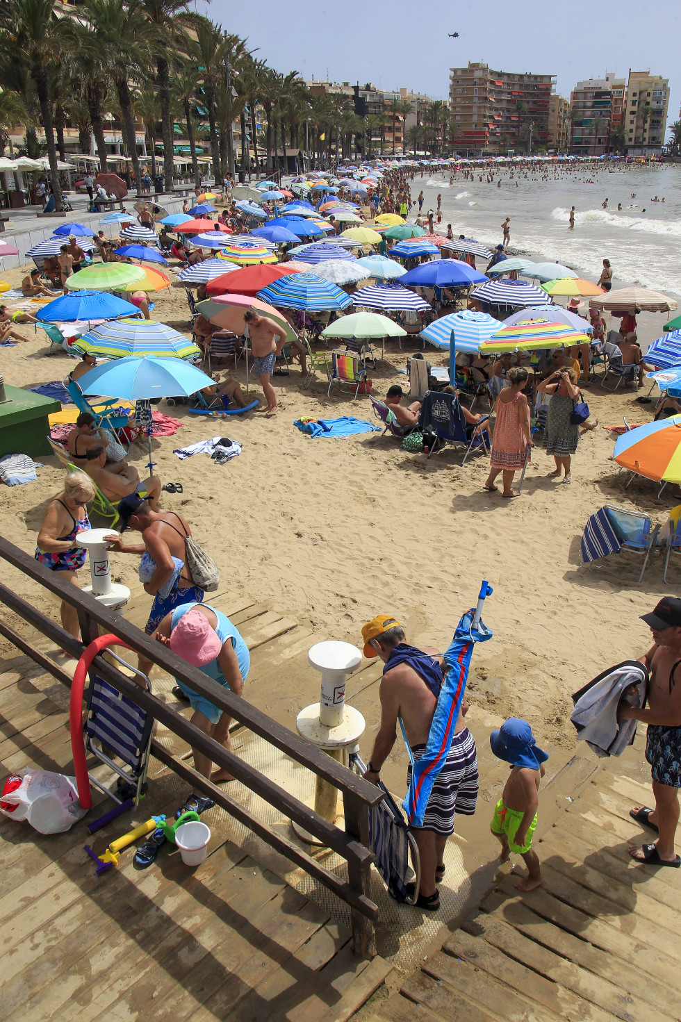 GRAFCVA2093. TORREVIEJA (ALICANTE), 30/07/2024.- Un gran número de personas disfrutan del buen tiempo en la playa de El Cura de Torrevieja cuando la Agencia Estatal de Meteorología (Aemet) ha establ