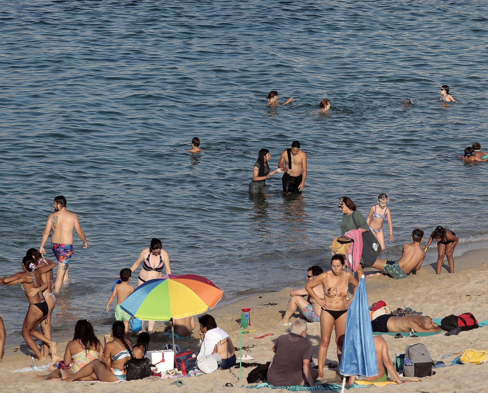 Personas disfrutan de un día de playa en A Coruña  @ Quintana