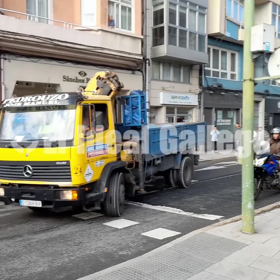 Un camión cargado de coches atasca Juan Flórez y obliga a los coches a circular por la acera