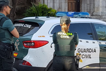 Archivo - Una agente y un coche de la Guardia Civil.