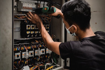 Un técnico repara un panel eléctrico