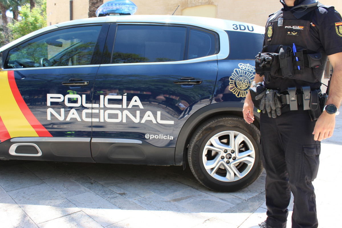 Agente junto a vehículo policial