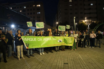 Vecinos de Agra do Orzán, con la pancarta en la que luce el molino del barrio  carlota blanco