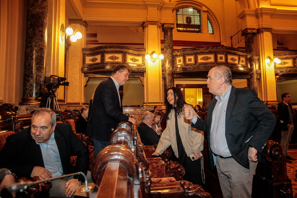 El portavoz del PP, Miguel Lorenzo (a la derecha), conversa con la bancada socialista en un pleno  quintana