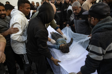 GAZA (---), 18/03/2025.- Palestinians stand around the body of a child who was killed in Israeli airstrikes, at the Al-Maadani Hospital in Gaza City, 18 March 2025. The Israeli forces on 18 March conf